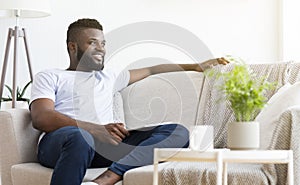 Comfortable weekend. Peaceful african man resting at home photo