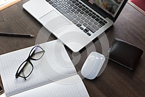 Comfortable working place. Close-up of comfortable working place in office with wooden table and laptop laying on it