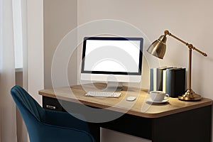 Comfortable workplace at home. Modern computer with blank screen and lamp on wooden desk. Mockup for design