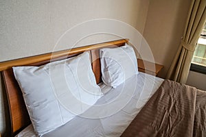 Comfy white pillows on mattress in luxury hotel double bedroom