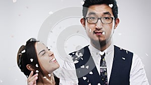 Comic couple, confetti and fun with crazy girlfriend dancing to annoy, irritate and frustrate boyfriend on a studio