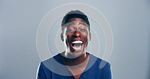 Comic, face and black man laughing in a studio for funny or silly joke in conversation with happiness. Smile, portrait