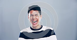 Comic, face and man laughing in a studio for funny or silly joke in conversation with happiness. Smile, portrait and