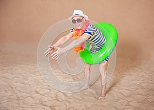 Comic funny man in vintage style striped swimsuit, colorful boa and sunglasses ready to dive with inflatable ring