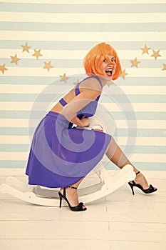 Comic and humorous concept. Woman playful cheerful mood having fun. Fun and entertainment. Girl wig rides swing little