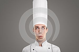 Comic male chef in white hat in studio