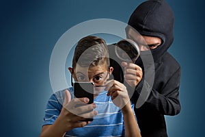 Comic masked man spying data from smartphone of teenager