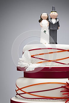 Comical bride and groom figurines on top of wedding cake