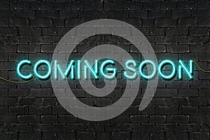 `COMING SOON` neon sign shining on black brick wall,Business concept