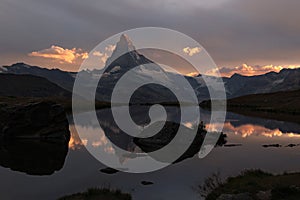 The coming sunset with dramatic alpenglow at the high mountain lake Stelisee and Matterhorn