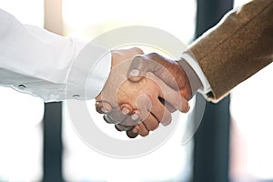 Coming to an agreement. Closeup shot of businesspeople shaking hands in an office.