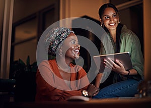 Coming together to conquer the deadline. two businesswomen working together on a computer in an office at night.