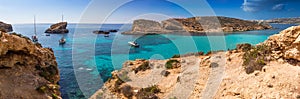 Comino, Malta - The beautiful Blue Lagoon with turquoise clear sea water, yachts and snorkeling tourists on a sunny summer