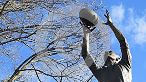 Commemorative statue of John Coleman Essendon Bombers legend marking the footy