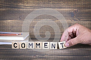 Comment. wooden letters on the office desk