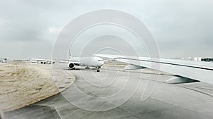 Commercial aeroplanes taxiing on a busy runway