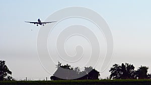 Commercial airline. Passenger plane landing at airport with beautiful sunset sky and clouds. Arrival flight. Airplane flying