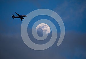 Commercial Airliner at Sunset Passes By Moon