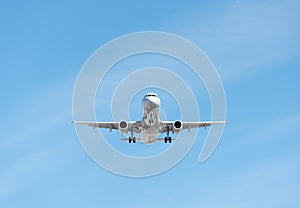 Commercial airplane flying in blue sky, full flap and landing ge