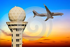 Commercial airplane flying over airport control tower