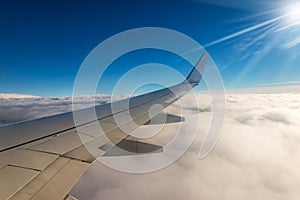 Commercial Airplane Flying over the Clouds - Looking through the Plane Window