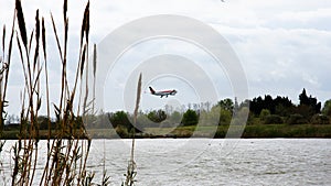 Commercial airplane flying over Llobregat river