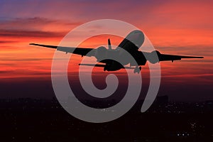 Commercial airplane flying over the night scene city on beautiful sunset background