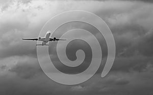Commercial airplane on grey sky and clouds with copy space. Failed vacation. Hopeless and despair concept. Moody sky and transport