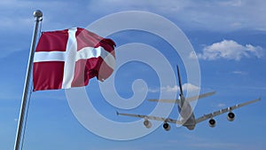 Commercial airplane landing behind waving Danish flag. Travel to Denmark conceptual 3D rendering
