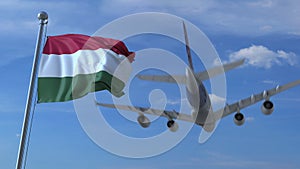 Commercial airplane landing behind waving Hungarian flag. Travel to Hungary conceptual 3D rendering