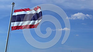 Commercial airplane landing behind waving Thai flag