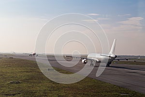 Commercial airplane queue taxiing to take off on runway photo
