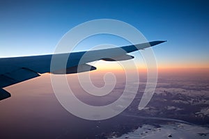 Commercial Aviation Jetplane flying over the ice mountain landscape on the Ocean Coast of Greenland. photo