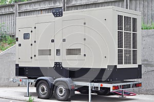 Commercial backup generator. A standby generator is a back-up electrical system that operates automatically. photo