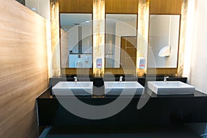 Commercial bathroom with three sink and mirror