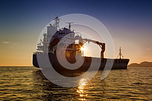 Commercial cargo ship at sunset