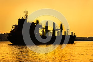 Commercial cargo ship at sunset