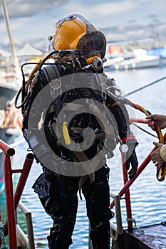 Commercial diver exiting water at harbor photo