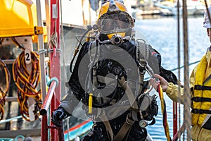 Commercial diver exiting water at harbor photo