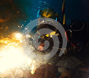 Commercial diver welding underwater at construction site