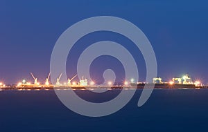 Commercial docks at sunset with ship and cranes