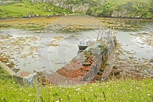 Commercial Fishing Boat Moored in Narrow Bay at Low Tide