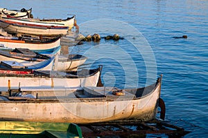 Commercial fishing boats rest on the shore by blue sea