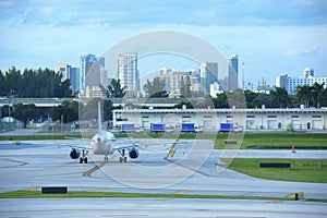 Commercial jet airliner airplane on the tarmac at international airport with Fort Lauderdale skyline in background