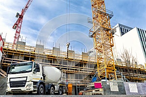 Commercial or residential corporate hightower building construction site with different heavy machinery. Concrete cement mixer