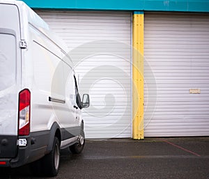 Commercial van for transporting cargo waiting by the warehouse g