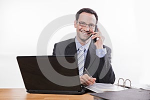 Committed employee with glasses smiling at phone