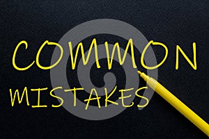 Common Mistakes Yellow Pen with yellow text own rent at the black background