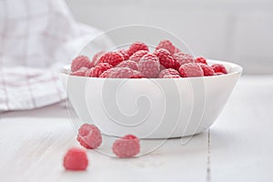 Common raspberries. Ripe red fruits in white bowl