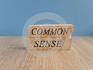 Common sense symbol. Concept words Common sense on beautiful brick blocks. Beautiful wooden table blue background. Business,
